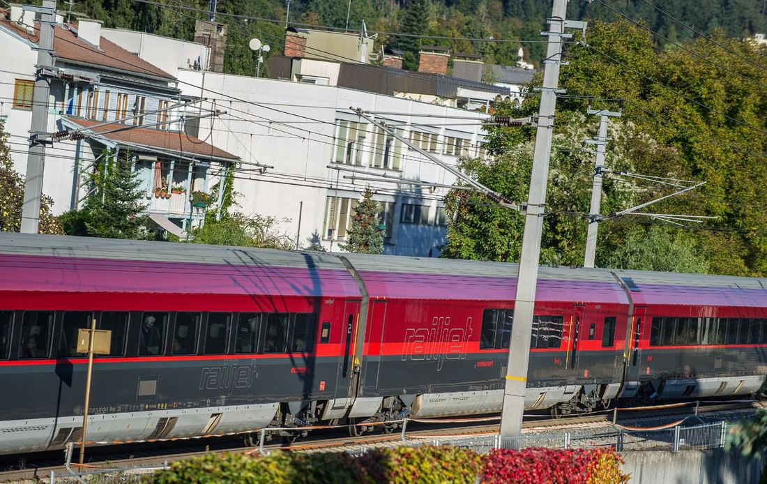 Railjet-Personenzug nahe an Wohnhäusern