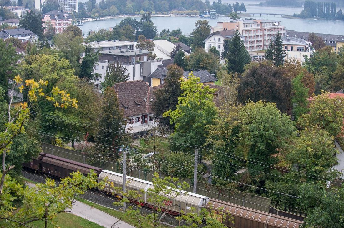 Güterzug im Ort mit Wörthersee im Hintergrund